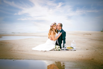 The bride and groom, the couple on the beach, beach, picnic with champagne and fruits