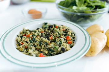 Mixed sauteed vegetables on dish over white background.