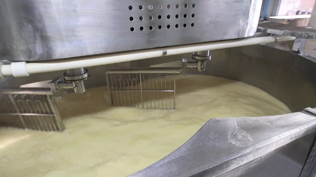 Large steel tank full of milk at dairy factory