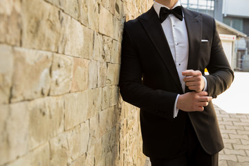 Male model in a suit in front of a stone wall