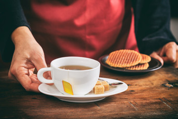 Waiter holding a cup of tea