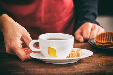 Waiter holding a cup of tea