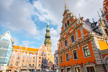View on the central square with famous houses of Blackheads and cathedral tower in Riga city, Latvia