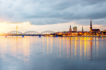Night view on the illuminated riverside with reflection on the river in Riga, Latvia