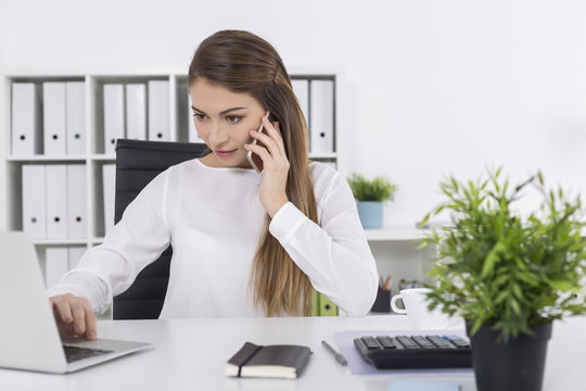 Woman in white office on her phone
