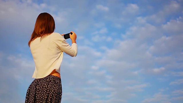 smart lady looks around and takes pictures of the beauty on the smartphone hd