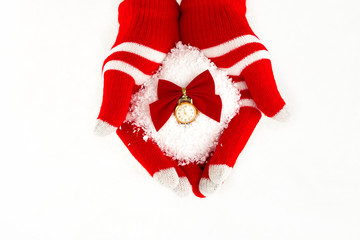 Christmas card, gloves on hands holding snow clock with time  fi