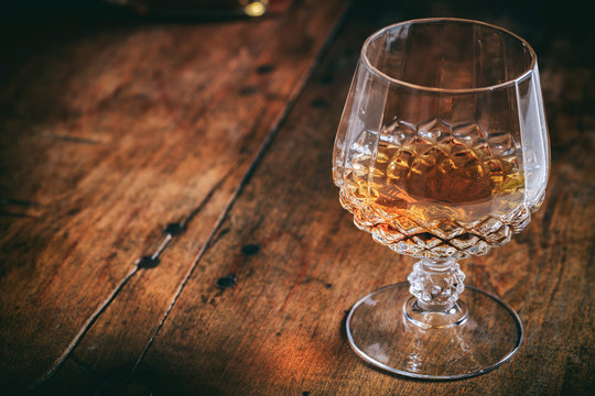 Crystal glass of cognac on a wooden background