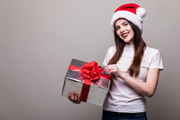 Christmas Woman with Gift Box. Beautiful Brunette Girl in Santa Hat isolated.