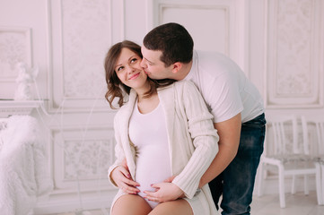 Family waiting for baby's birth. A pregnant woman and her husband wearing white clothing