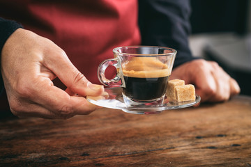 Waiter holding a cup of espresso