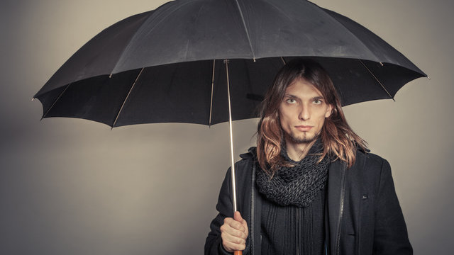 Handsome fashion man portrait wearing black coat.