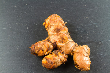 Turmeric root on dark slate background