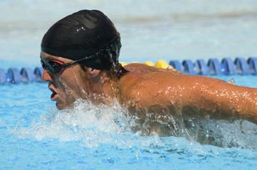 Side view of male athlete racing in a swimming pool