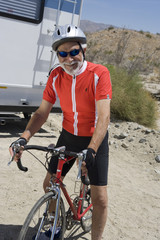 Portrait of a happy senior man riding bicycle