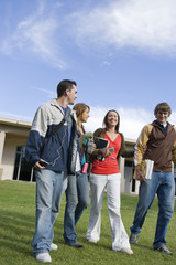 Happy college friends walking together at college campus