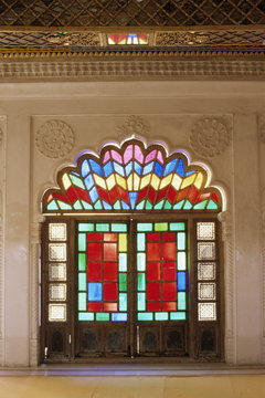 Original old stained glass in doors and decorative jali wood carving in door, Mehrangarh Fort, Jodhpur, Rajasthan state