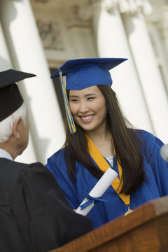 Graduate Receiving Diploma Outside University