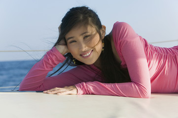 Portrait of happy young woman relaxing on sailboat
