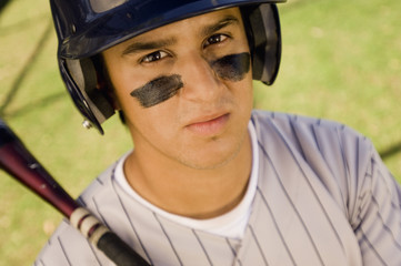 Portrait of a young Caucasian baseball player holding bat