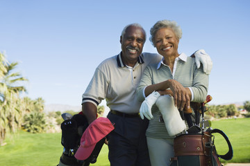 Portrait of happy senior couple in golf course smiling - obrazy, fototapety, plakaty