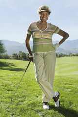 Portrait of a smiling senior woman standing on golf course