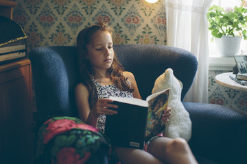 Sweden, Smaland, Mortfors, Portrait of reading girl (10-11)