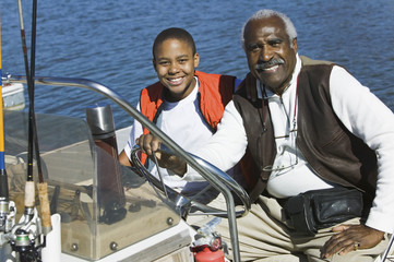 Portrait of an African American man sitting with grandson in a boat