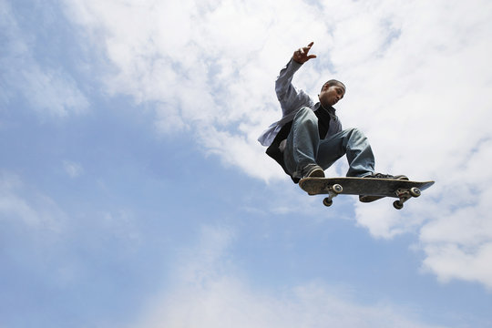 Low angle view of young man performing trick on skateboard
