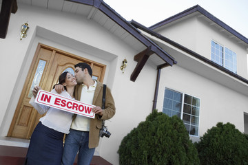 Portrait of a happy couple kissing outside new house
