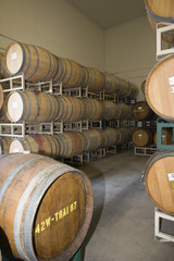 Stack of wine barrels on a stand stored in an old cellar of the winery