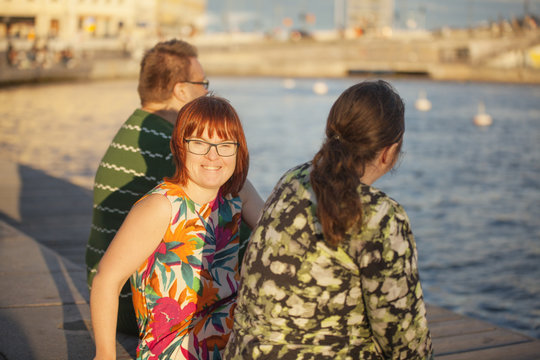 Sweden, Stockholm, Old Town, Woman with down syndrome sitting on promenade with friends