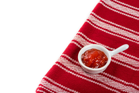 Container of ketchup on the table in natural light