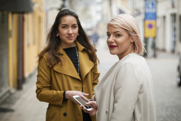 Sweden, Skane, Kirstianstad, Portrait of two young women on street