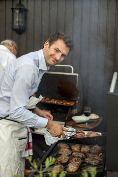 Sweden, Two men grilling meat