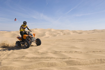 Young man riding quad bike in desert © MDBPIXS
