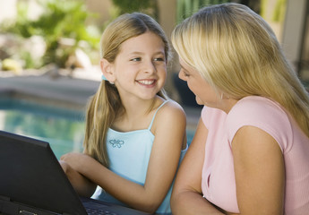 Mother and Daughter Using Laptop on Patio