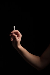 female hand with joint of marijuana on black background 