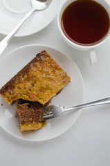 Caramel Peanut-Topped Brownie Cake with A Cup of Tea.