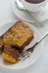 Caramel Peanut-Topped Brownie Cake with A Cup of Tea.