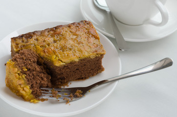 Caramel Peanut-Topped Brownie Cake with A Cup of Tea.