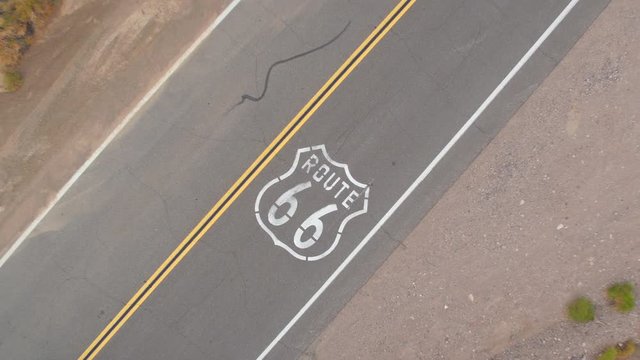 AERIAL: Black car on road trip driving along the historic Route 66 in USA