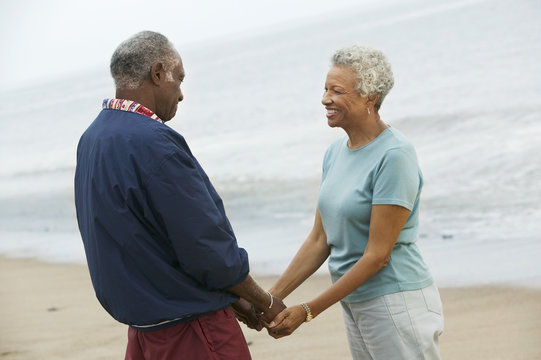 Senior couple holding hands on beach