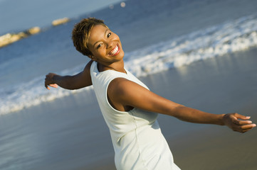 Portrait of cheerful African American woman enjoying vacation on beach