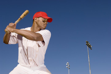Confident African American baseball batter waiting to strike the ball