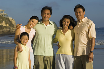 Portrait of happy family with girl posing on beach