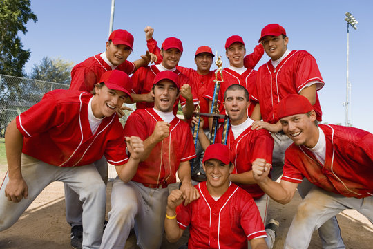 Portrait of excited baseball team holding trophy with pride