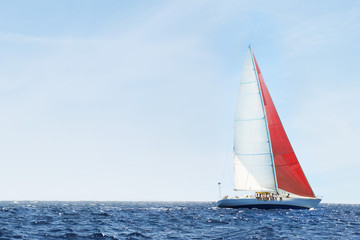 Side view of a sailboat in the peaceful blue ocean against sky