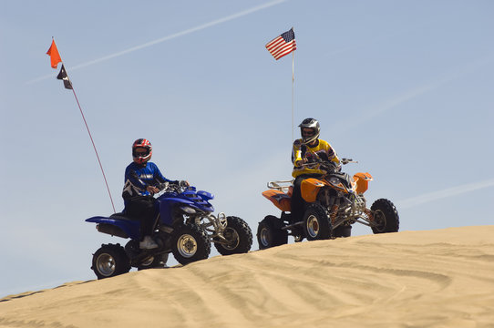 Two Young Men With Quad Bikes On Sand Dune