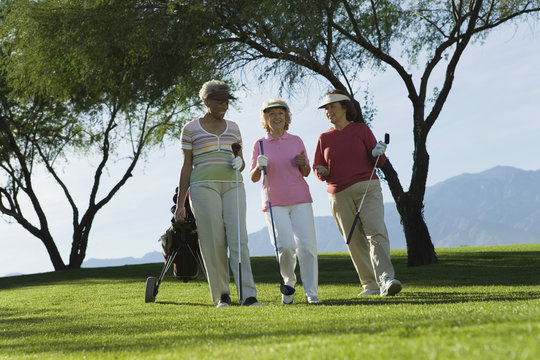 Three Mature Women Walking On Golf Course